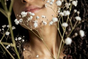 woman-holding-white-flowers-face