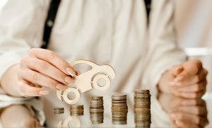 woman on a mirrored table on a roller coaster of coins leads a machine of wood up . High quality photo