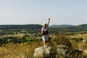 woman-standing-rock-raising-hand-air