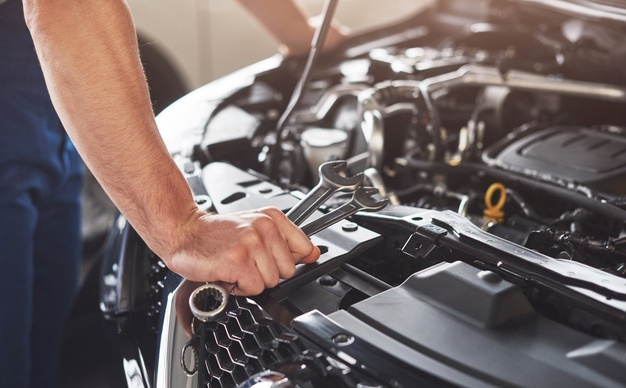 muscular-car-service-worker-repairing-vehicle_146671-19605