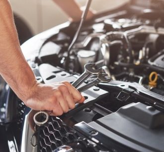 muscular-car-service-worker-repairing-vehicle_146671-19605